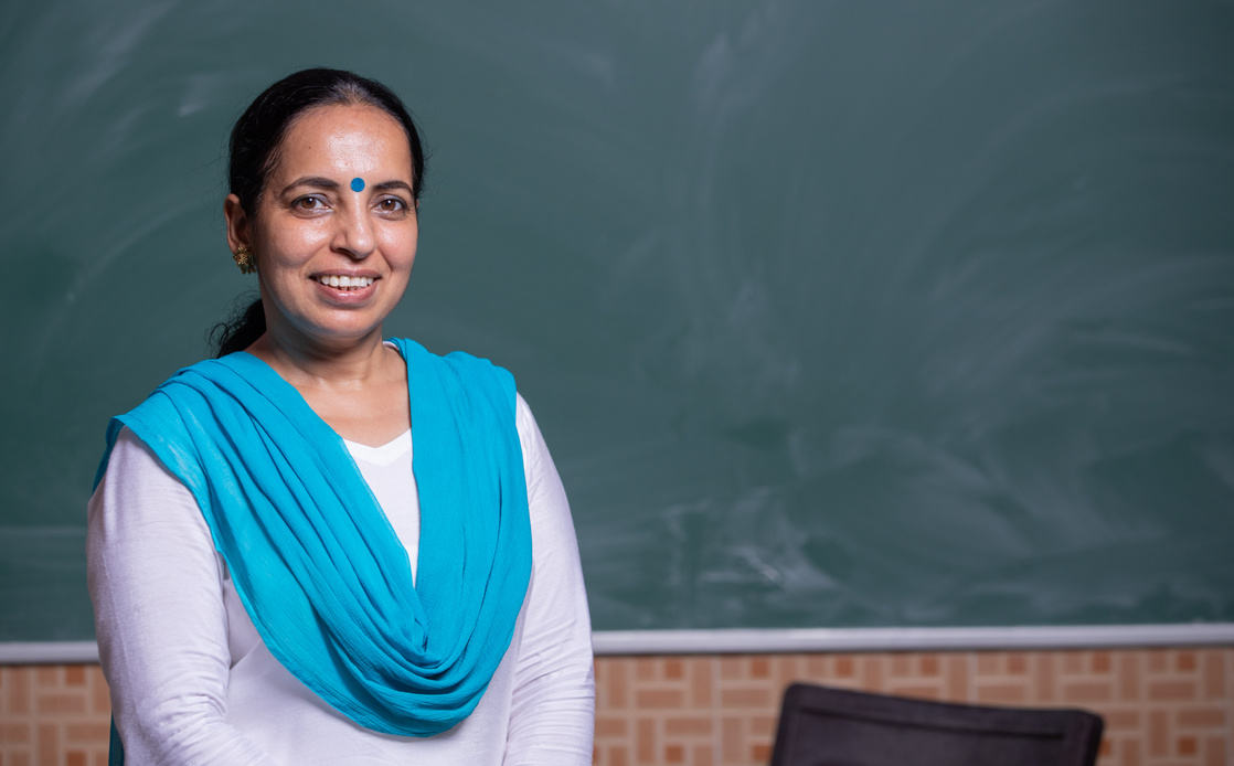 Portrait of indian teacher standing front of Blackboard